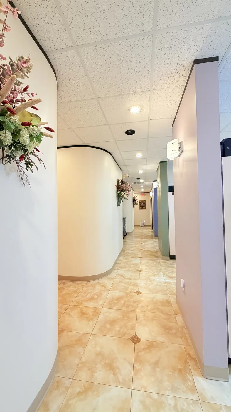 The curved hallway at SoftDental connecting the operatories, decorated with floral arrangements